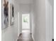 Bright hallway leading to a door, with light flooring and modern artwork on the walls at 3101 N 15Th St, Tampa, FL 33605