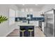 Modern kitchen with blue backsplash, white cabinets, island with bar stools, and stainless steel appliances at 3101 N 15Th St, Tampa, FL 33605