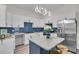 Bright kitchen with white cabinets, island with bar stools, blue backsplash, and stainless steel refrigerator at 3101 N 15Th St, Tampa, FL 33605