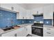 Kitchen featuring stainless steel appliances, a blue tiled backsplash, and light countertops at 3101 N 15Th St, Tampa, FL 33605