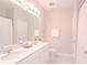 Bright bathroom with double sink, white cabinets, quartz countertop, and framed mirror at 34329 Evergreen Hill Ct, Wesley Chapel, FL 33545