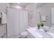 Clean, well-lit bathroom featuring a vanity with quartz countertop and a shower with a white curtain at 34329 Evergreen Hill Ct, Wesley Chapel, FL 33545