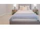 Comfortable bedroom with a gray upholstered bed, neutral walls, side tables, and decorative lamps at 34329 Evergreen Hill Ct, Wesley Chapel, FL 33545