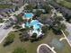 An aerial view of the community pool area, featuring lush landscaping, a clubhouse and a basketball court at 34329 Evergreen Hill Ct, Wesley Chapel, FL 33545