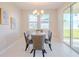 Dining room with a chandelier, a modern table, six chairs, neutral walls, and tile floors at 34329 Evergreen Hill Ct, Wesley Chapel, FL 33545