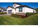 Beautiful single-Gathering home featuring manicured lawn, stone accents, and a gray two-car garage at 34329 Evergreen Hill Ct, Wesley Chapel, FL 33545