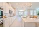 Bright kitchen with white cabinets, modern appliances, an island, and an open layout to the dining area at 34329 Evergreen Hill Ct, Wesley Chapel, FL 33545