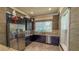 Stylish kitchenette with dark cabinetry, granite countertops, and stainless-steel appliances; modern and efficient at 34329 Evergreen Hill Ct, Wesley Chapel, FL 33545