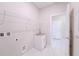 Practical laundry room with a sink, storage shelves, tile flooring, and access to another room at 34329 Evergreen Hill Ct, Wesley Chapel, FL 33545