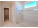 Bathroom featuring a glass-enclosed shower with decorative tile and walk-in closet access at 34329 Evergreen Hill Ct, Wesley Chapel, FL 33545
