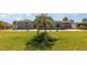 Large grassy backyard featuring a pool, mature landscaping, and ample space for recreation at 4 Oakland Hills Ct, Rotonda West, FL 33947