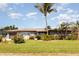 Charming single-story home with manicured lawn and mature palm trees at 4 Oakland Hills Ct, Rotonda West, FL 33947