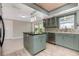 Stylish kitchen with island, tile backsplash, and stainless steel appliances at 4 Oakland Hills Ct, Rotonda West, FL 33947