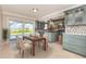 Open kitchen with dining area, blue cabinets, tile backsplash, and sliding glass doors to the pool area at 4 Oakland Hills Ct, Rotonda West, FL 33947