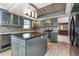Modern kitchen with island, stainless steel appliances, and wood-look tile flooring at 4 Oakland Hills Ct, Rotonda West, FL 33947