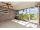 Enclosed lanai with tile flooring, ceiling fan, and serene backyard view at 4 Oakland Hills Ct, Rotonda West, FL 33947