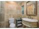 The bathroom showcases elegant travertine walls paired with a decorative mirror and a charming marble sink at 4127 53Rd S Ave, St Petersburg, FL 33711