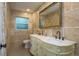 Bright bathroom featuring dual sinks, an ornate vanity, and a large framed mirror at 4127 53Rd S Ave, St Petersburg, FL 33711
