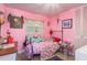 Pink bedroom featuring a metal bed frame, an ornate window covering, and colorful decorations at 4127 53Rd S Ave, St Petersburg, FL 33711