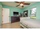 The bright bedroom features a mounted television, ceiling fan, and a window with neighborhood views at 4127 53Rd S Ave, St Petersburg, FL 33711