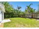 Lush backyard with healthy green lawn and mature trees, providing a private outdoor space at 441 Village Dr, Tarpon Springs, FL 34689