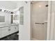 Bright bathroom features a walk-in shower with white tile and a vanity with marble countertops at 441 Village Dr, Tarpon Springs, FL 34689