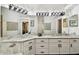 Bathroom features a spacious vanity with double sinks, marble countertops, and modern lighting fixtures at 441 Village Dr, Tarpon Springs, FL 34689