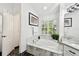 Clean bathroom with a soaking tub, natural light, and black marble flooring with an artistic aesthetic at 441 Village Dr, Tarpon Springs, FL 34689