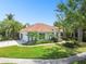 Beautiful home featuring a tile roof, attached garage, and tropical landscaping at 441 Village Dr, Tarpon Springs, FL 34689