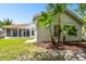 Beautiful home exterior with a screened-in lanai, tile roof, and well-manicured yard at 441 Village Dr, Tarpon Springs, FL 34689