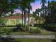 Charming single-story home with a tile roof, arched entryway and lush tropical landscaping at 441 Village Dr, Tarpon Springs, FL 34689