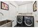Clean and functional laundry room equipped with modern appliances and ample cabinet space at 441 Village Dr, Tarpon Springs, FL 34689
