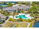 Gorgeous aerial view of a large community pool with palm trees, seating, and beautiful landscaping at 5020 Mill Pond Rd # 3158 & 3160, Wesley Chapel, FL 33543