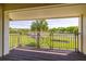 Balcony view of golf course with palm trees and a small pond, overlooking a green lawn at 5020 Mill Pond Rd # 3158 & 3160, Wesley Chapel, FL 33543