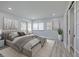 Bright bedroom with a large bed, gray walls, wood floors, windows, and modern decor at 5020 Mill Pond Rd # 3158 & 3160, Wesley Chapel, FL 33543
