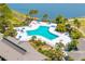 Aerial view of a sparkling community pool with plenty of seating and tropical landscaping at 5020 Mill Pond Rd # 3158 & 3160, Wesley Chapel, FL 33543