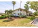 Picture of condo's exterior view surrounded by green grass, well-trimmed bushes and palm trees at 5020 Mill Pond Rd # 3158 & 3160, Wesley Chapel, FL 33543