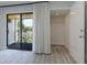 A room with wood-look floors and a large sliding door opening to a balcony and closet at 5020 Mill Pond Rd # 3158 & 3160, Wesley Chapel, FL 33543