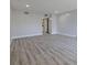 Bright room with light gray wood-look floors leading to a doorway and closet with sliding doors at 5020 Mill Pond Rd # 3158 & 3160, Wesley Chapel, FL 33543