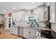 Bright kitchen featuring white cabinets, stainless steel appliances and sink with a view to the backyard at 506 Avocado Dr, Seffner, FL 33584