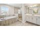 Well-appointed bathroom featuring a glass-enclosed shower, soaking tub, and double vanity with modern lighting at 5335 Wolf Creek Dr, Apollo Beach, FL 33572
