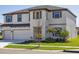 Two-story home with a three car garage, manicured lawn and a neutral color palette at 5335 Wolf Creek Dr, Apollo Beach, FL 33572