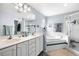 Bright bathroom with double sink vanity, soaking tub, and tiled glass-door shower at 6018 Gentle Ben Cir, Wesley Chapel, FL 33544