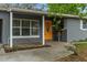 Exterior view of the home's orange front door, porch, and adjacent windows at 611 E River Dr, Temple Terrace, FL 33617