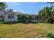 Expansive backyard with green lawn, mature trees, and a screened-in porch area attached to the house at 6314 Soratrace St, Lithia, FL 33547