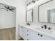 Elegant bathroom featuring dual sinks, white cabinets, and stylish mirrors and a bedroom view at 6314 Soratrace St, Lithia, FL 33547