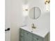 Bathroom featuring a vanity with gold hardware, elegant lighting, and a modern round mirror at 6314 Soratrace St, Lithia, FL 33547