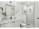 A modern bathroom features a sleek vanity, framed mirror and step-in shower with custom tile work at 6314 Soratrace St, Lithia, FL 33547