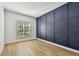 Bedroom view showcasing a modern wall panel feature, plantation shutters and wood floors at 6314 Soratrace St, Lithia, FL 33547