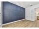 Bedroom view showcasing a modern wall panel feature, plantation shutters and wood floors at 6314 Soratrace St, Lithia, FL 33547